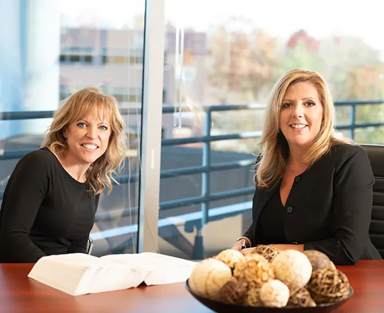 Amy Smith and Dawn Kaplan at a conference table in a bright office.